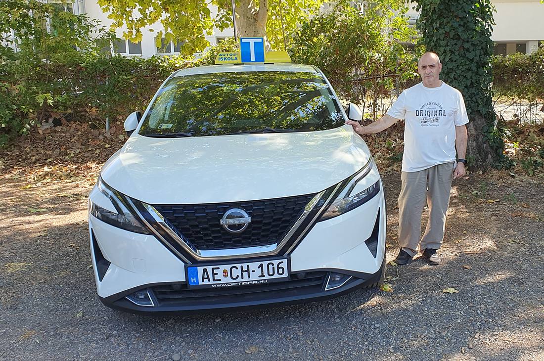 Anda János az oktatóautó mellett